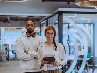 In a modern office African American young businessman and his businesswoman colleague, with her striking orange hair, engage in collaborative problem-solving sessions
