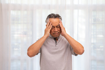 Sick unhappy senior elderly man touching head serious depressed feeling headache thinking of...