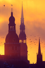 A beautiful cityscape of Riga, Latvia during sunrise. Church towers against colorful sky. City...
