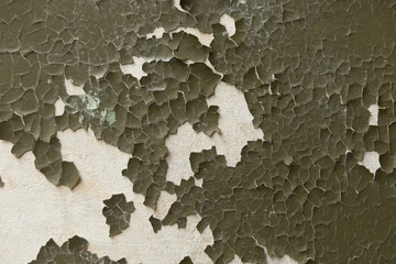 An old, pealed paint on the wall of abandoned building. Cracked paint texture.