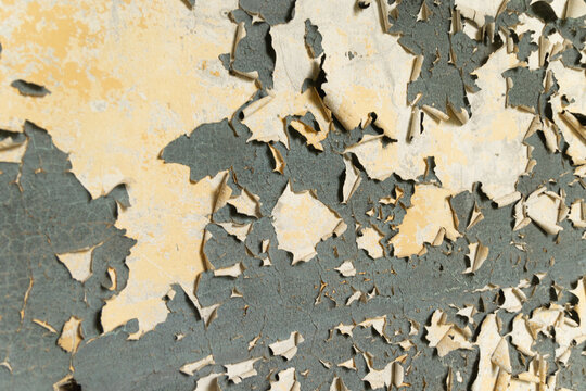 An old, pealed paint on the wall of abandoned building. Cracked paint texture.