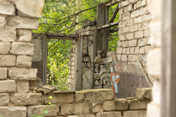 A broken, empty window of building ruins from Soviet times. Collapsed brick wall with window. Latvia, Europe.