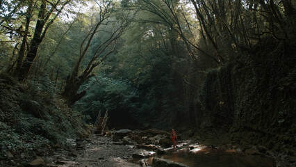 Hikers mother and boy standing in jungles near cold stream. Creative. Lush green forest and river.