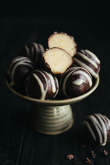 Close-up view of chocolate candies with green pistachio filling inside at black background