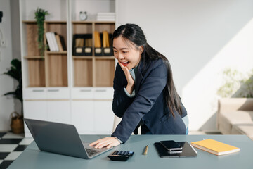 Asian business woman are delighted and happy with the work they do on their tablet, laptop and...