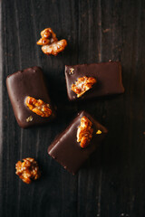 Halva in chocolate at dark background with nuts