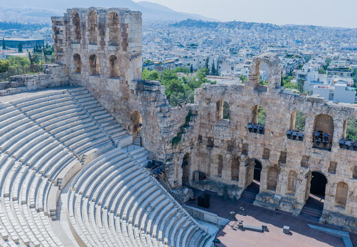 Ancient theater ruins with the city skyline in the background, showing old stone structures, in Athens, Greece