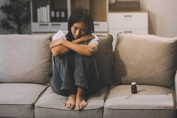 Upset woman frustrated by problem with work or relationships, sitting on couch, embracing knees, covered face in hand, feeling despair and anxiety, loneliness, having psychological trouble