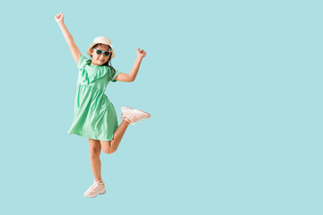 Happy smiling asian little girl and jumping, dancing were hat and sunglasses posing, Fashion summer holiday concept, Full body isolated on blue background