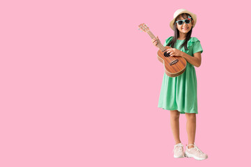 Happy smiling asian little girl were hat and sunglasses playing Ukulele exuding fun. Full body isolated on pink  background