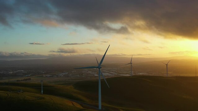 Aerial tracking shot of a Eolic wind farm in California, moody evening in USA