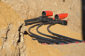 Laying polyethylene pipes for high-voltage cables underground.