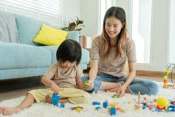 Happy Asia mother play and learn toy blocks with the little girl. Funny family is happy and excited...