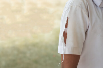 student shirt with tear at arm from playing in daily life activity in school