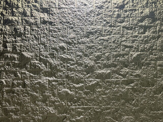 Gray Rough Finish Concrete Block Wall with Night Lighting Shadows Texture Background