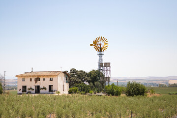 An American farm with a windmill is an iconic image that evokes rural life and connection to...