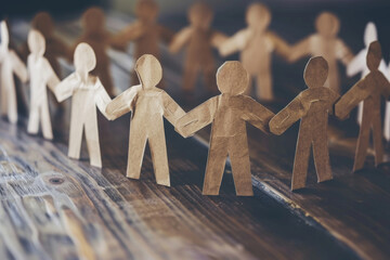 Paper Cutout Figures Holding Hands on Wooden Table