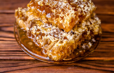 honey in honeycombs on a brown wooden background
