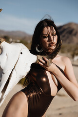 girl in a swimsuit in the desert, fashion beauty girl in the desert, A girl holds a buffalo skull
