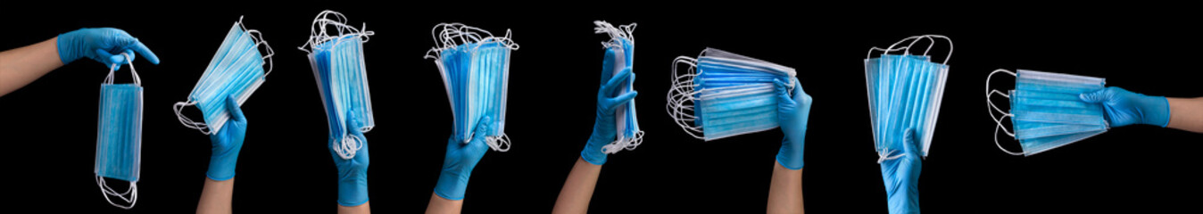 Doctor's hand in medical gloves holding a pile of masks isolated on black