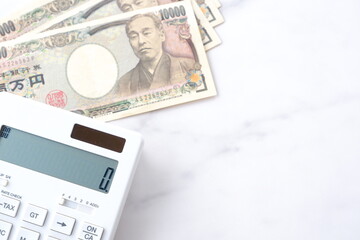 福沢諭吉の肖像の一万円紙幣と電卓
