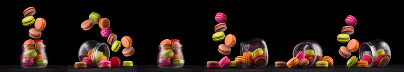 Jar of french colorful macaroon or macaron on wooden table isolated on black