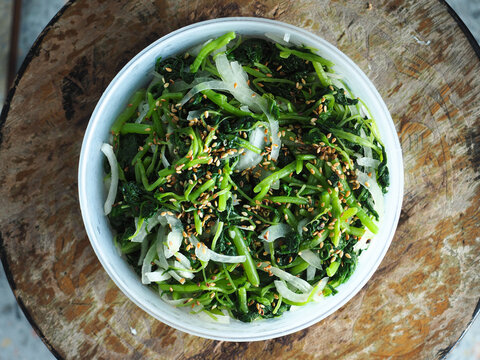 top view bowl of spinach with white sesame seed and onion salad