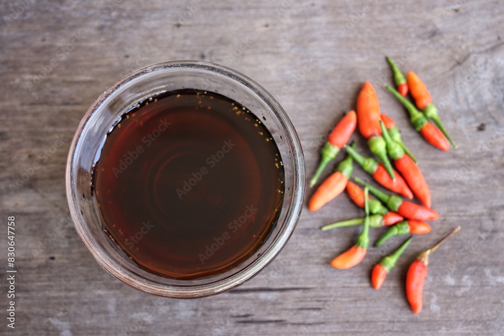 Wall mural fish sauce with red chili on wood table