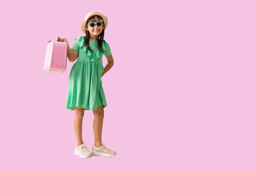 Happy asian little girl posing with wear a hat with sunglasses with suitcase, Travel concept holiday summer fashion green dress, full body isolated on pink  background