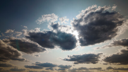 Obraz premium beautiful blue sky with dark dramatic cumulus clouds and sunlight for abstract background
