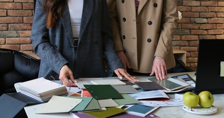 Marketing team reviewing color palettes during creative meeting. Professionals collaborate on...