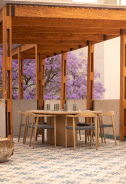 mesa de madera en la terraza con arboles de fondo