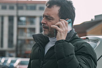 mature man using phone on the street