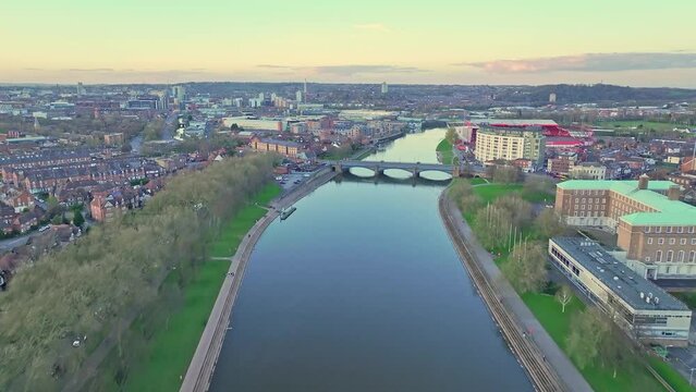 A flight along the River Trent, whose still water reflects the late sunset sky. A Trent Bridge is seen in the background, Nottingham, England