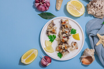 Pickled rapan meat with oil, spices and greens. Healthy seafood rich of omega