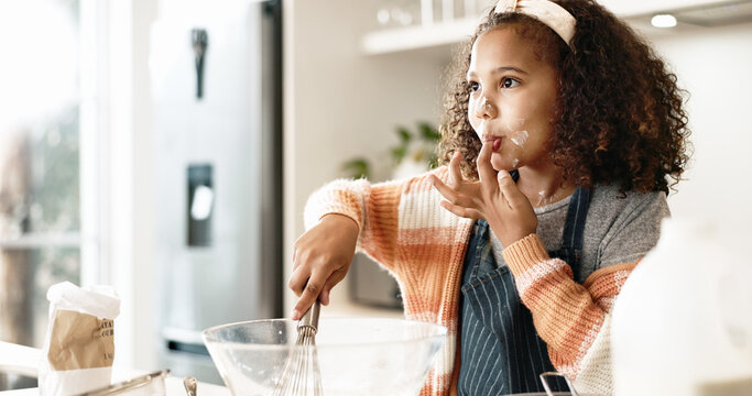 Girl, baking and taste in kitchen or house with batter, home and motor skills or childhood development for culinary education. Cooking, cookie dough and happy dessert, bowl and ingredients with whisk