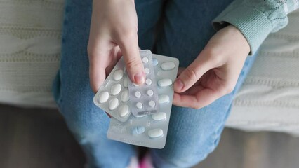 Top view three blisters with tablets in hands of unrecognizable gently lie.