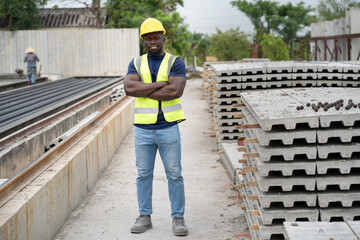 Cross arm Portrait African engineer man with precast cement at precast cement outdoor factory	