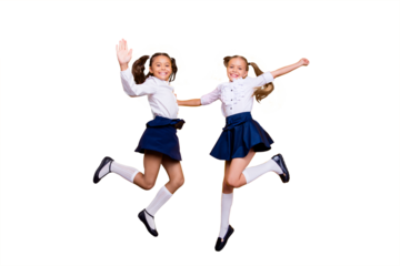 Dynamic images. 1-september concept. Full length, legs, body, size portrait of careless, cheerful, small girls in dark blue skirt, white blouse and black shoes jumping isolated on yellow background