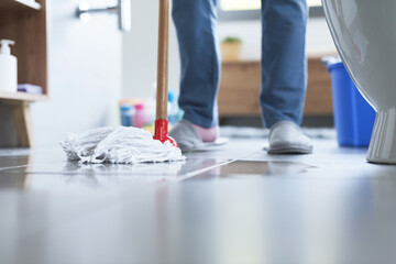 Woman cleaning up the floor with a mop