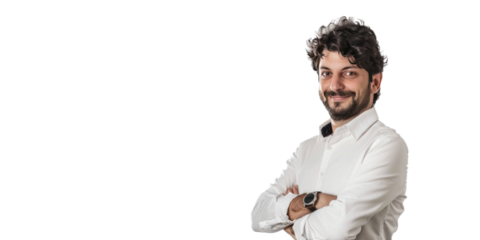 A professional portrait of a man with curly hair and a beard, wearing a white shirt and smiling confidently with arms crossed.