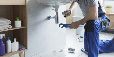 Professional plumber replacing pipes at home