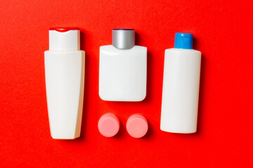 Cosmetics SPA branding mock-up, top view with copy space. set of tubes and jars of cream flat lay on colored background