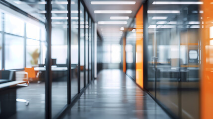 Beautiful blurred background of a modern office interior in gray tones with panoramic windows, glass partitions and orange color accents.