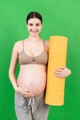 Pregnant Girl Holding Yoga Mat Standing Over Colored Background. Studio Shot, Free Space For Design