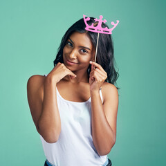 Girl, portrait and crown birthday in studio as gen z on green background for fashion, style and...