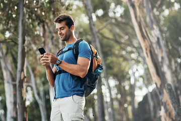 Man, hiking and smile with smartphone in forest for browsing internet, networking and social media....