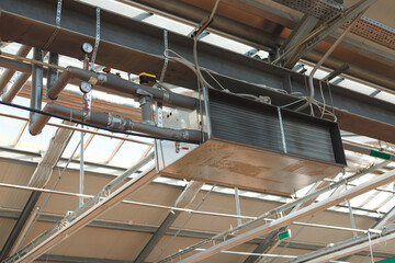 Industrial air conditioning handling unit suspended on frame construction under ceiling