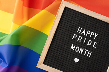 Colorful rainbow flag with a message board displaying 'Happy Pride Month'. Celebrating LGBTQ+...