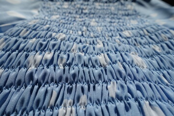 Fototapeta premium Close view of light blue and white rayon fabric with shirring